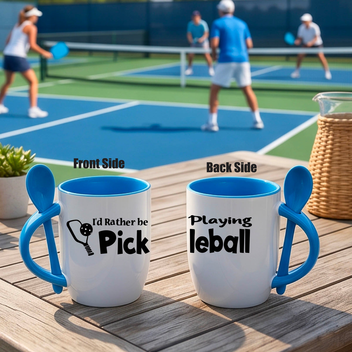 A white and blue 12 ounce coffee mug with a built in spoon in the handle with and a fun pickleball paddle and ball graphic and the text “I’D RATHER BE PLAYING PICKELBALL”