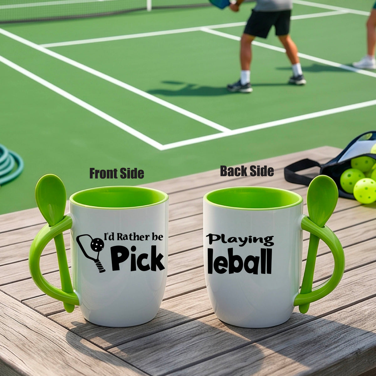 A white and green 12 ounce coffee mug with a built in spoon in the handle with and a fun pickleball paddle and ball graphic and the text “I’D RATHER BE PLAYING PICKELBALL”