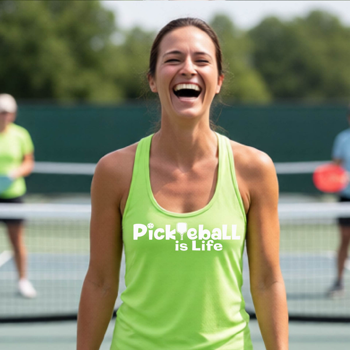 A woman wearing a lime green racerback tank top with the slogan 'Pickleball is Life' printed in white across the back, with a pickleball paddle replacing the L. 