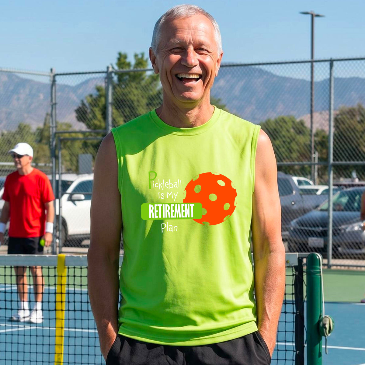A man on a pickleball court, wearing a lime green sleeveless athletic t-shirt, with the words “Pickleball is my Retirement Plan” in green and white with an orange pickleball illustration in the background.