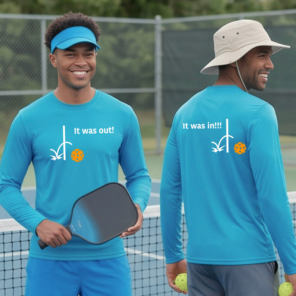 Two men showing a bright blue long-sleeve t-shirt with a white design of ‘IT WAS OUT!’ and a colorful pickleball on the front, and the back design with a white ‘IT WAS IN!!!’ and a colorful pickleball, standing on a pickleball court.