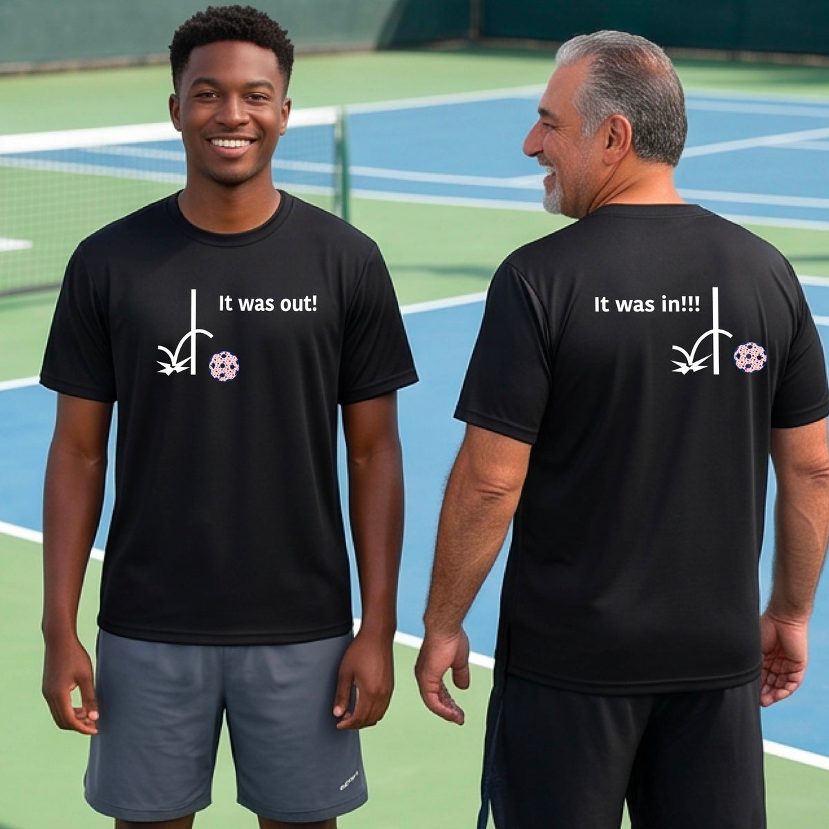 Two men showing a black short-sleeve t-shirt with a white design of ‘IT WAS OUT!’ and a colorful pickleball on the front, and the back design with a white ‘IT WAS IN!!!’ and a colorful pickleball, standing on a pickleball court. 