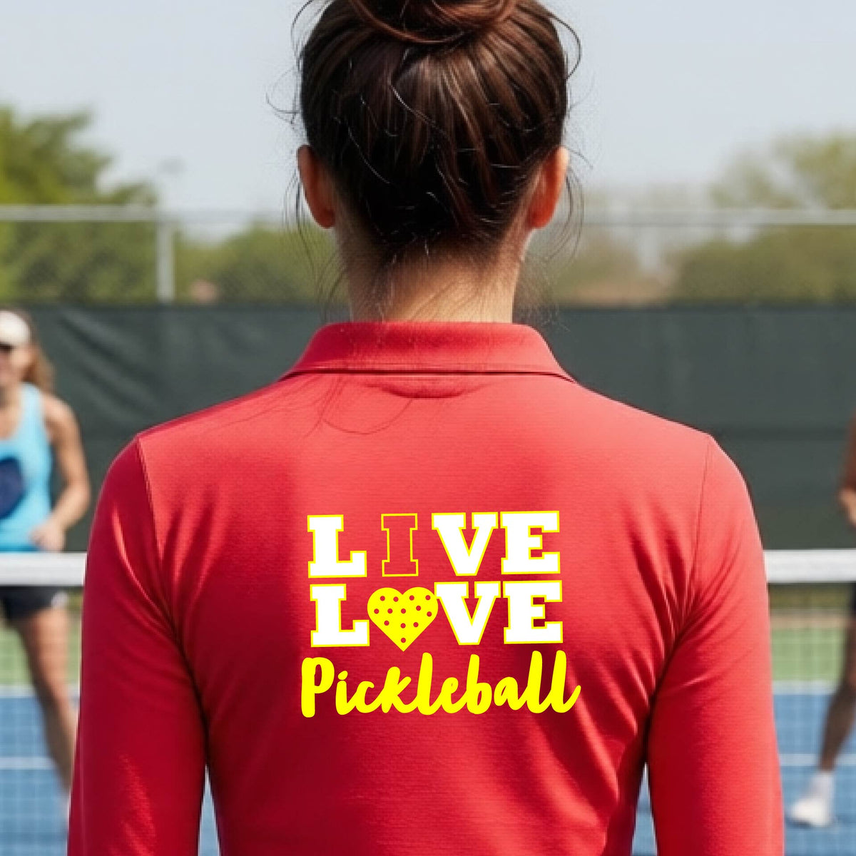 A woman viewed from behind wearing a red quarter-zip athletic pullover with a yellow and white graphic on the back that reads 'LIVE LOVE Pickleball'.