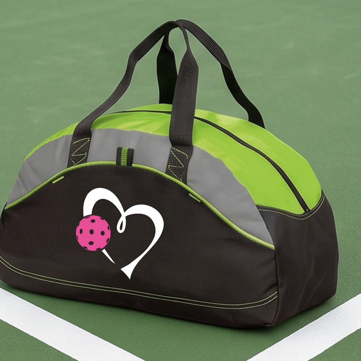 A black and lime green pickleball duffel bag with gray panels, featuring a white heart outline and a pink pickleball graphic on the front,.