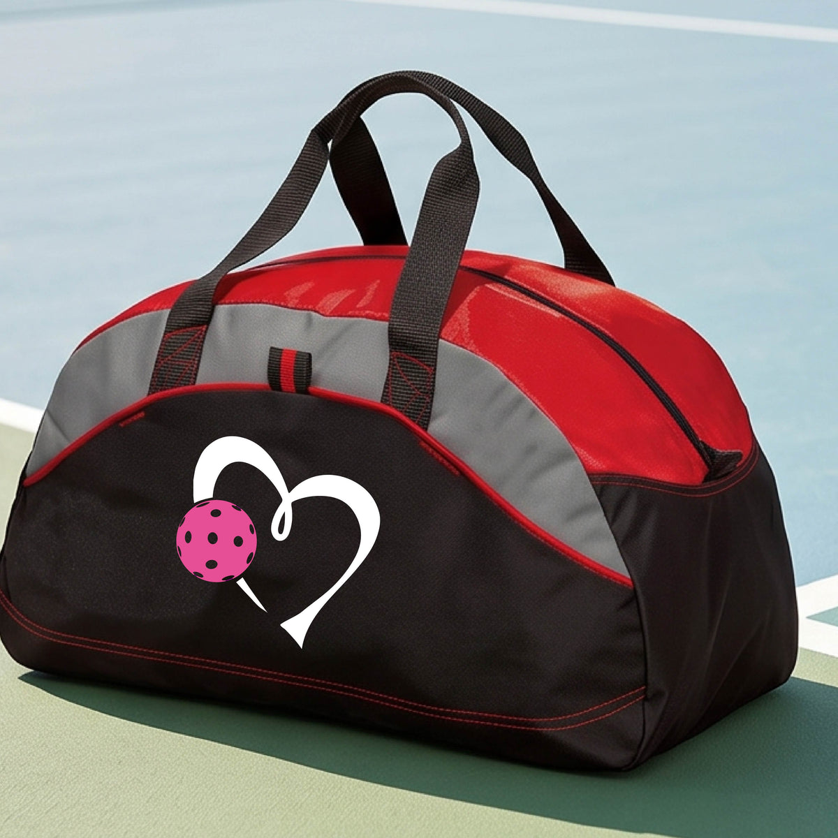 A black and red pickleball duffel bag with gray panels, featuring a white heart outline and a pink pickleball graphic on the front,.