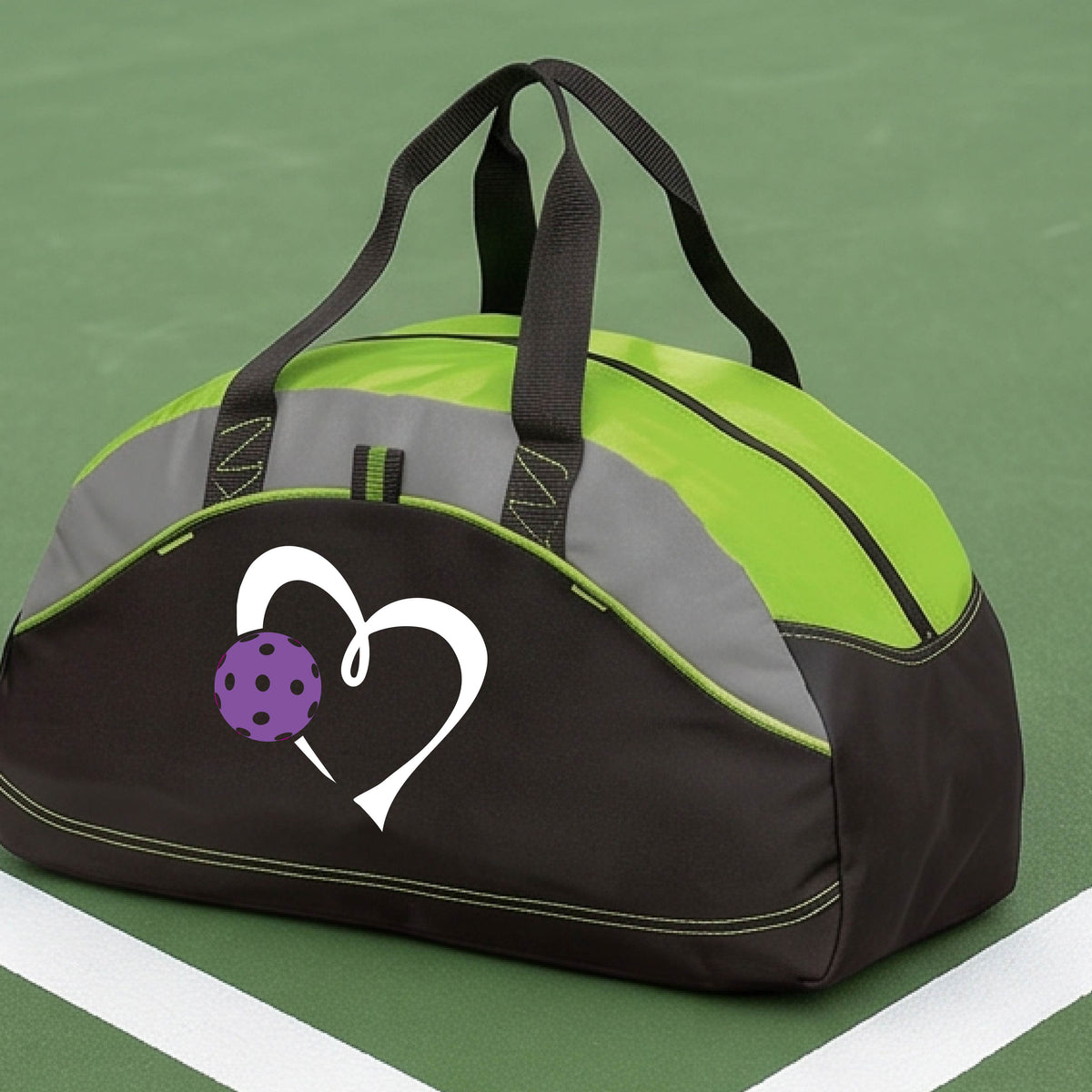 A black and lime green pickleball duffel bag with gray panels, featuring a white heart outline and a purple pickleball graphic on the front,.