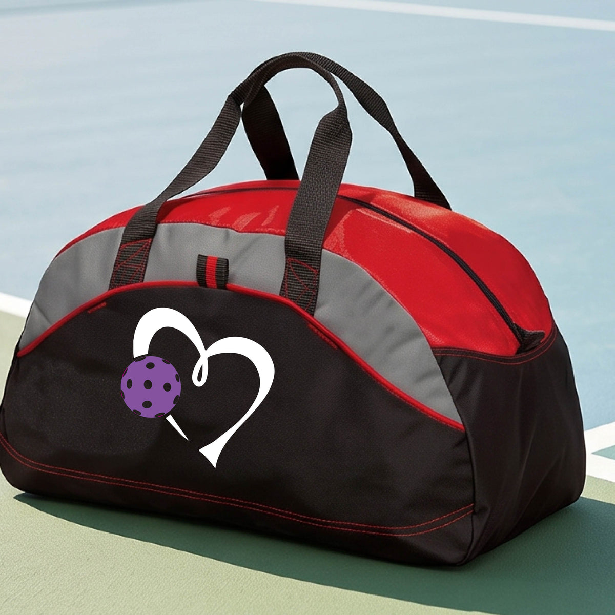 A black and red pickleball duffel bag with gray panels, featuring a white heart outline and a purple pickleball graphic on the front,.