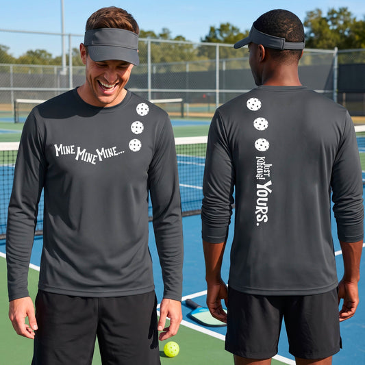Two men on a pickleball court wearing matching gray long-sleeve t-shirts. One shows the front with the text 'MINE MINE MINE' along with three pickleball graphics. and the back text 'JUST KIDDING YOURS, along with three pickleball graphics.