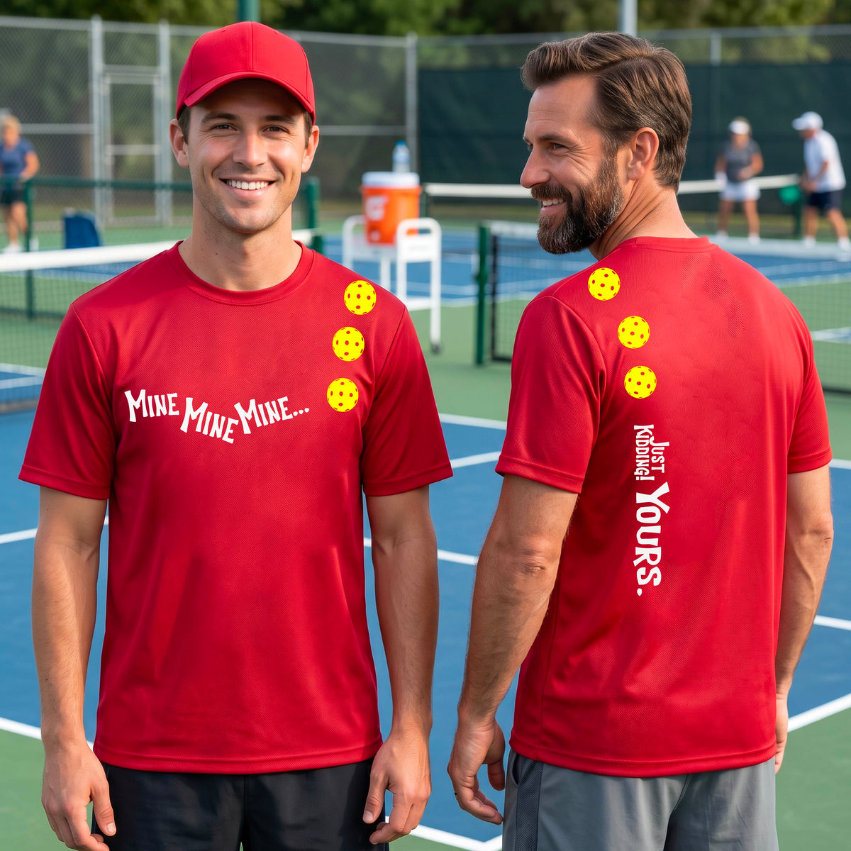 Two men on a pickleball court wearing matching red short-sleeve t-shirts. One shows the front with the text 'MINE MINE MINE' along with three pickleball graphics. and the back text 'JUST KIDDING YOURS, along with three pickleball graphics.