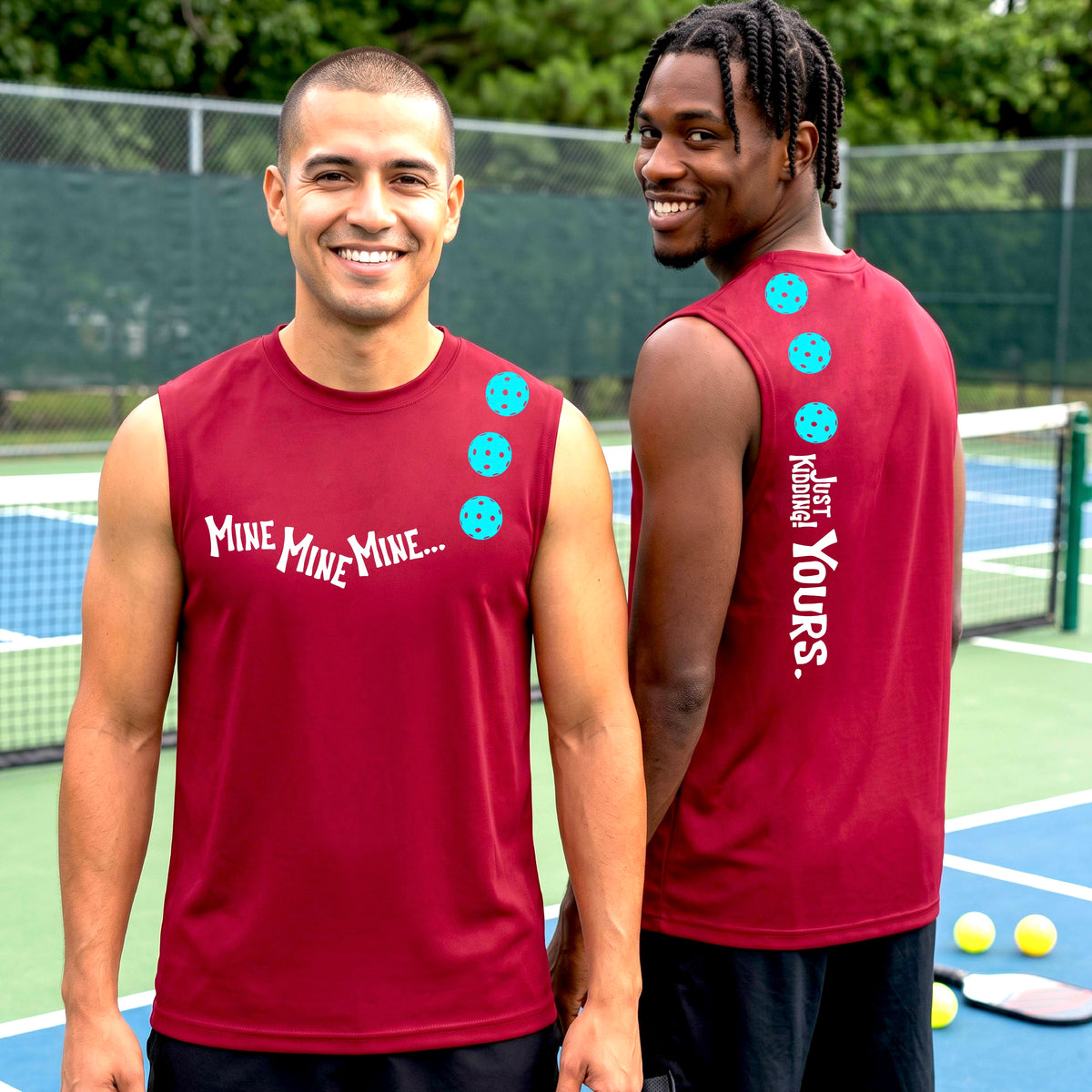 Two men on a pickleball court wearing matching red sleeveless t-shirts. One shows the front with the text 'MINE MINE MINE' along with three pickleball graphics. and the back text 'JUST KIDDING YOURS, along with three pickleball graphics.