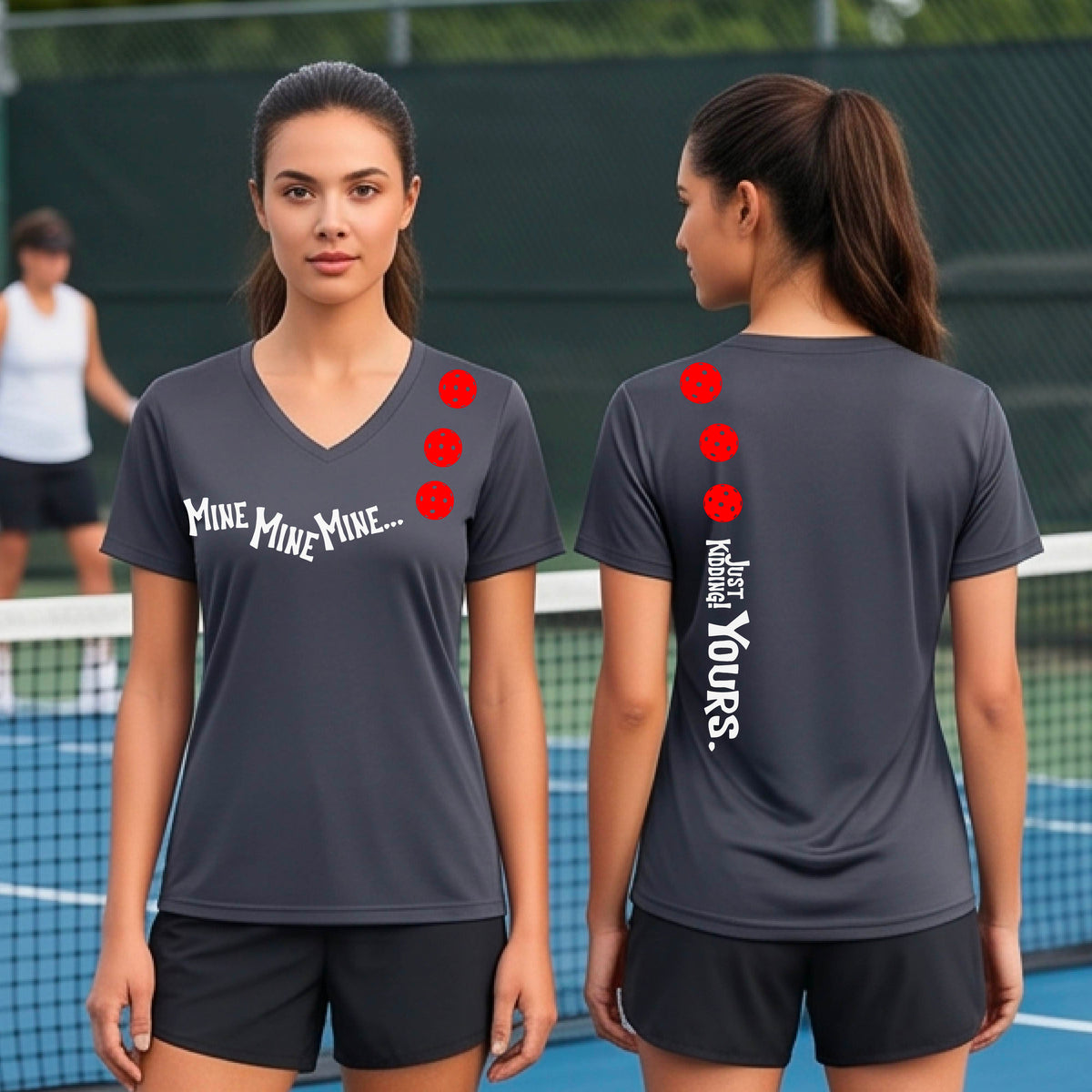 Two women on a pickleball court wearing matching dark gray short-sleeve v-neck t-shirts.  One shows the front with the text 'MINE MINE MINE' along with three pickleball graphics. and the back text 'JUST KIDDING YOURS, along with three pickleball graphics.