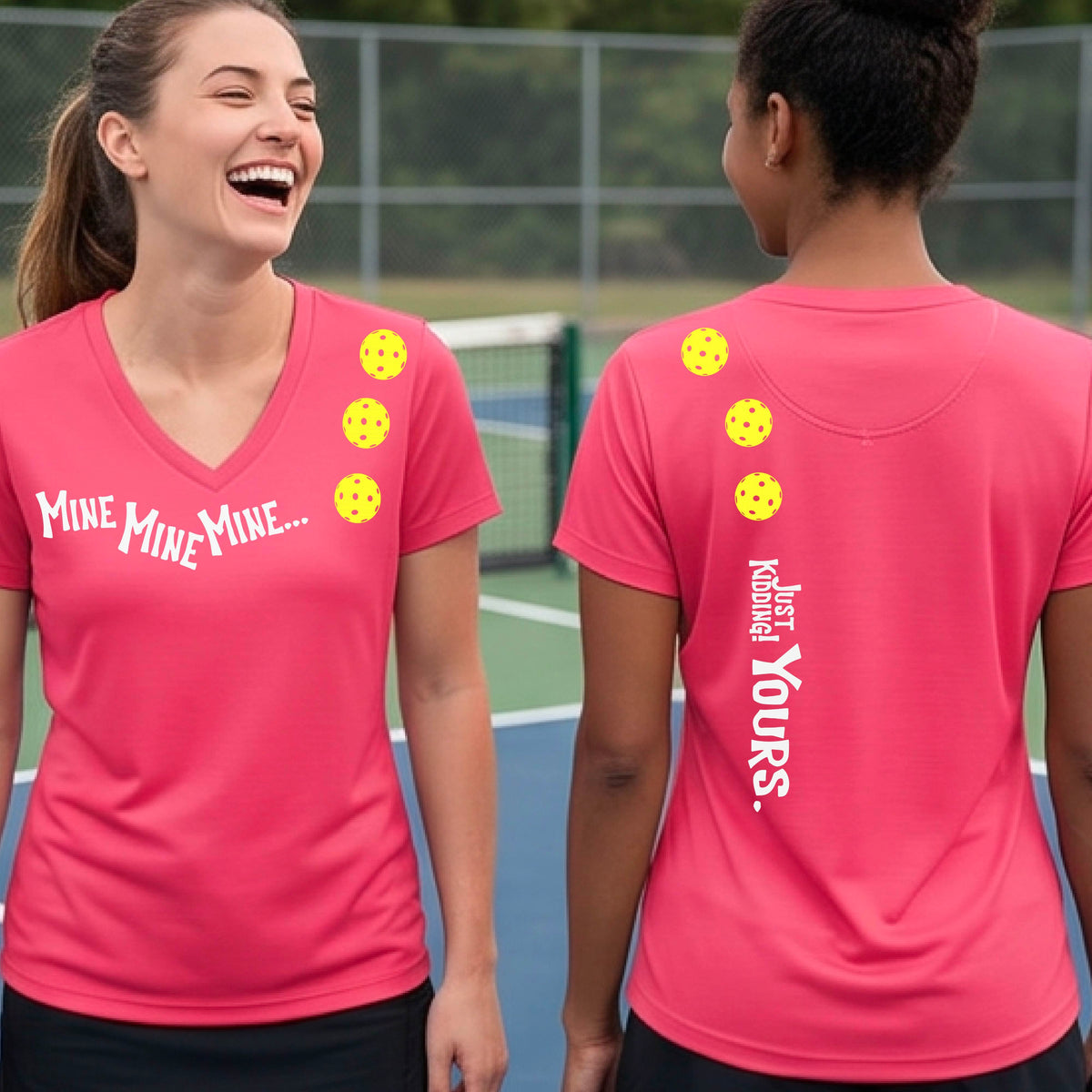Two women on a pickleball court wearing matching coral pink short-sleeve v-neck t-shirts.  One shows the front with the text 'MINE MINE MINE' along with three pickleball graphics. and the back text 'JUST KIDDING YOURS, along with three pickleball graphics.
