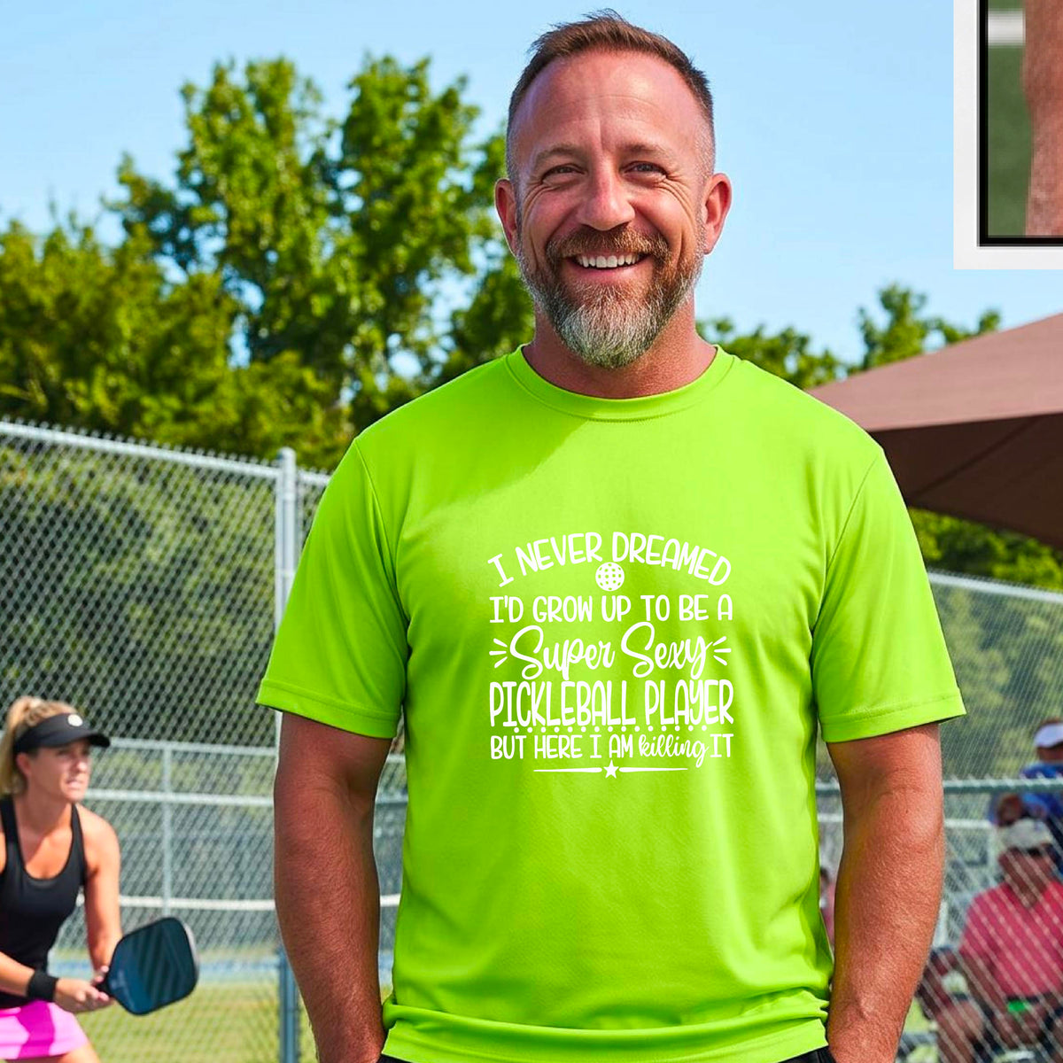 A man on a pickleball court wearing a lime green short-sleeve t-shirt with a white graphic of the text:  ‘I Never Dreamed I’d Grow Up To Be A Super Sexy Pickleball Player But Here I Am Killing It!’, standing on a pickleball court.