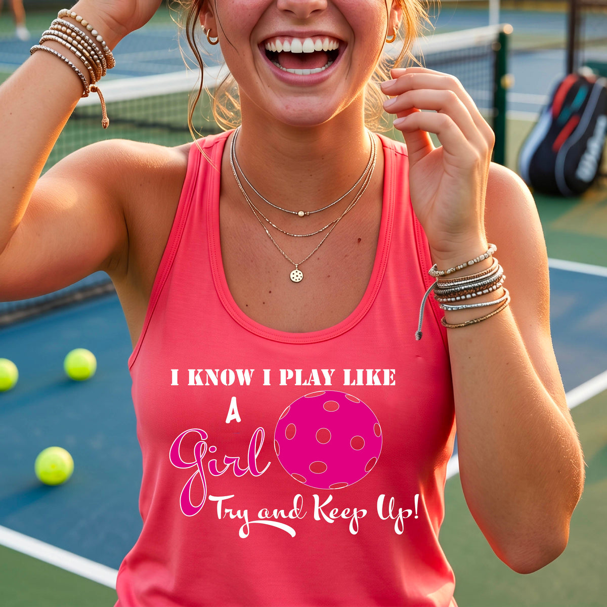 A woman laughing while wearing a coral pink racerback tank top with a pink and white graphic that reads 'I KNOW I PLAY LIKE A Girl Try and Keep Up!' with a pink pickleball illustration.