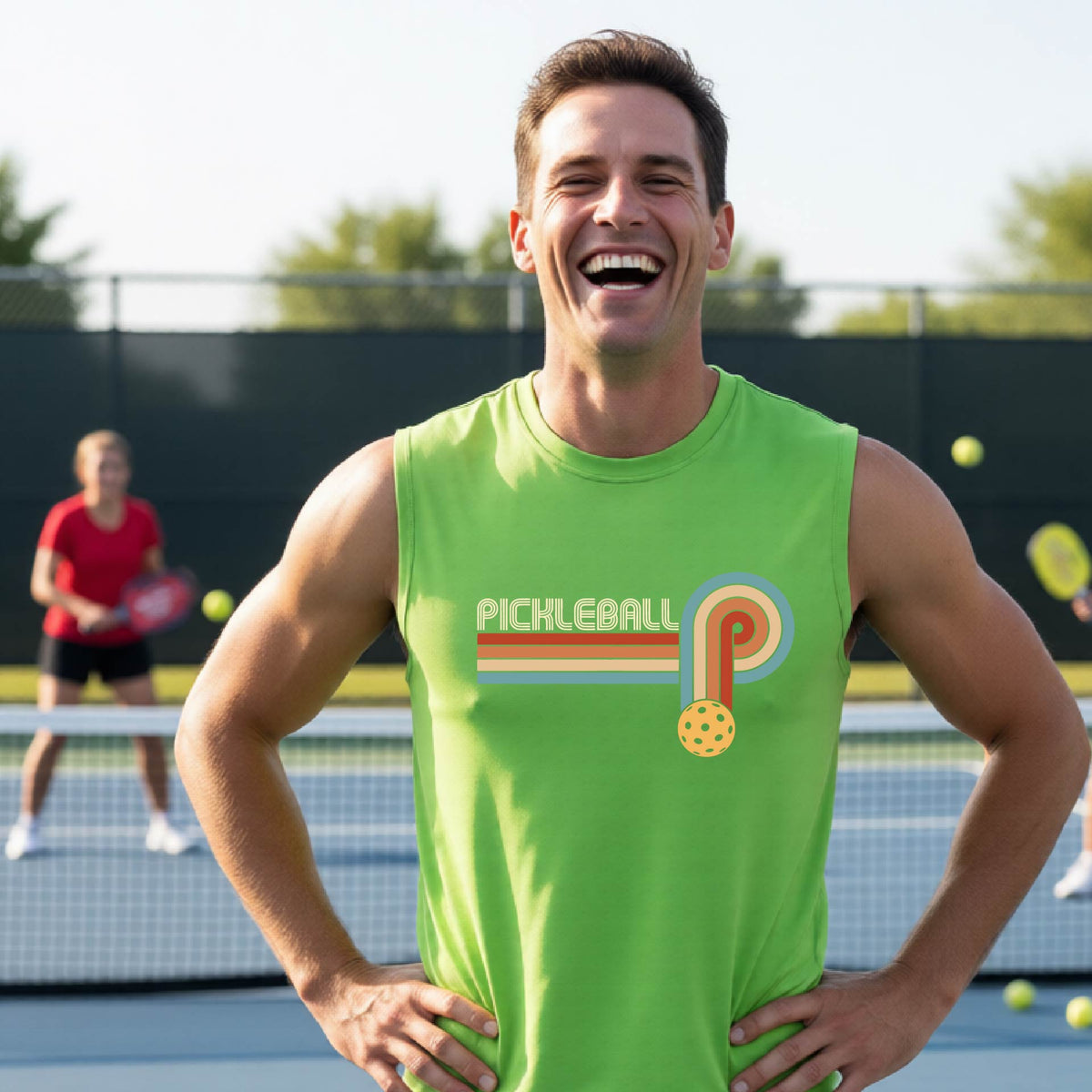 A man on a pickleball court wearing a lime green sleeveless t-shirt with a retro graphic of the word  “pickleball” on top of four colored lines that turn and go down ending in an orange pickleball, standing on a pickleball court.