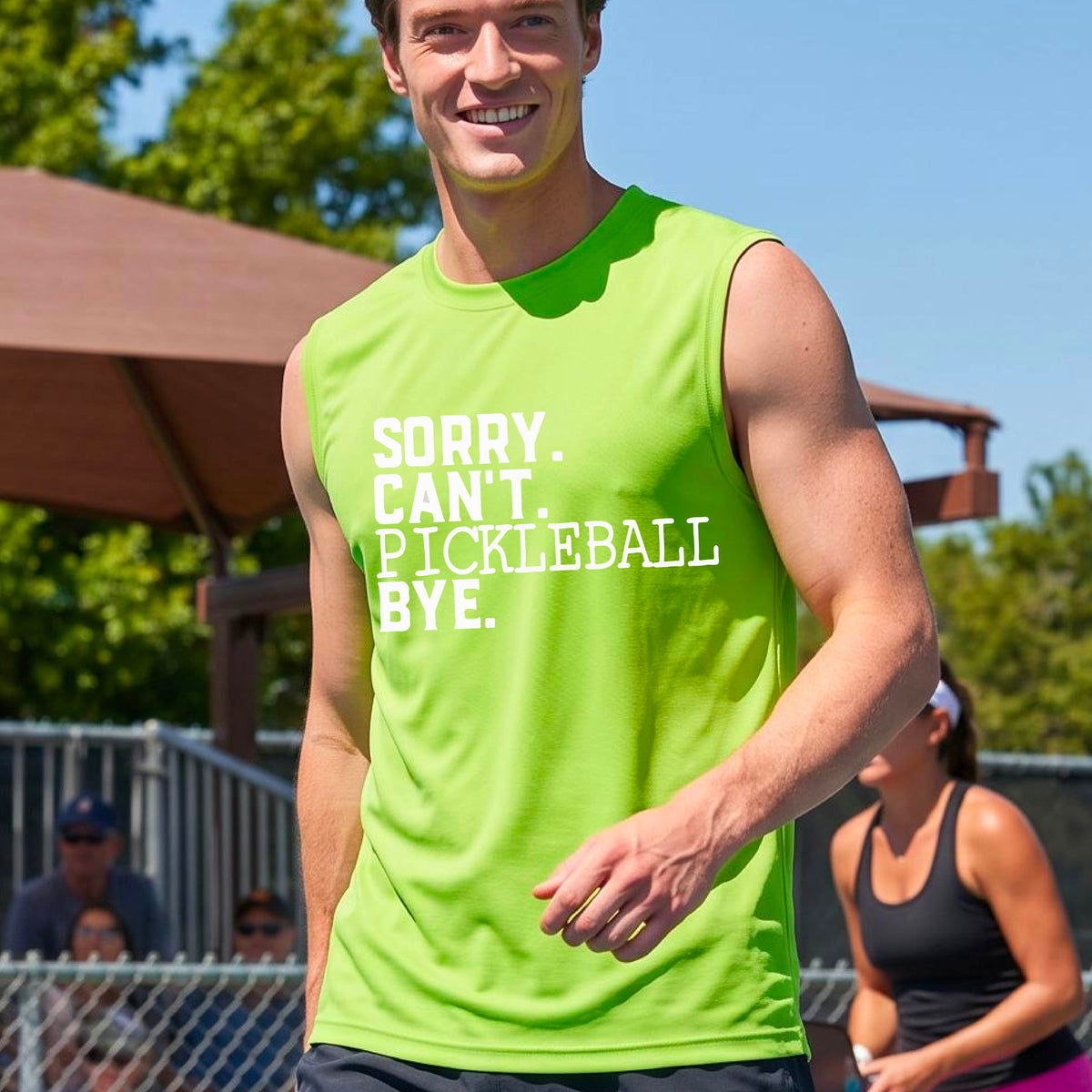 A man on a pickleball court wearing a lime green sleeveless t-shirt with a white graphic of the words  “SORRY. CAN’T. PICKLEBALL BYE” each on a separate line, on the front of the shirt. 