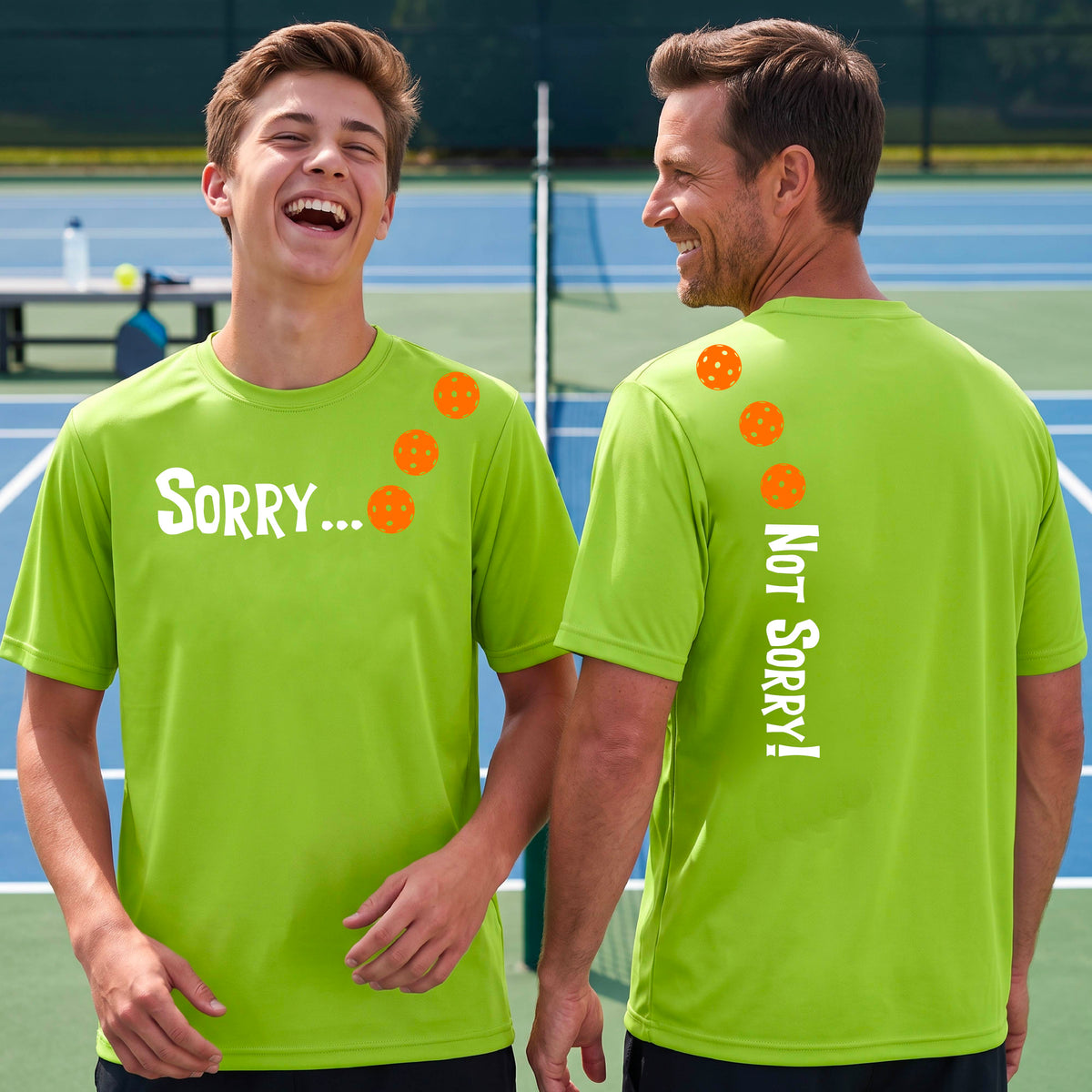 Two men on a pickleball court wearing lime green short-sleeve t-shirts with a front/back graphic design.  The front features the playful word “SORRY…” in bold white lettering, accented with three colorful pickleballs arranged diagonally across the upper chest.  The back design features “NOT SORRY!” in bold white lettering running vertically down the upper back, with three matching colorful pickleballs positioned above lettering. 