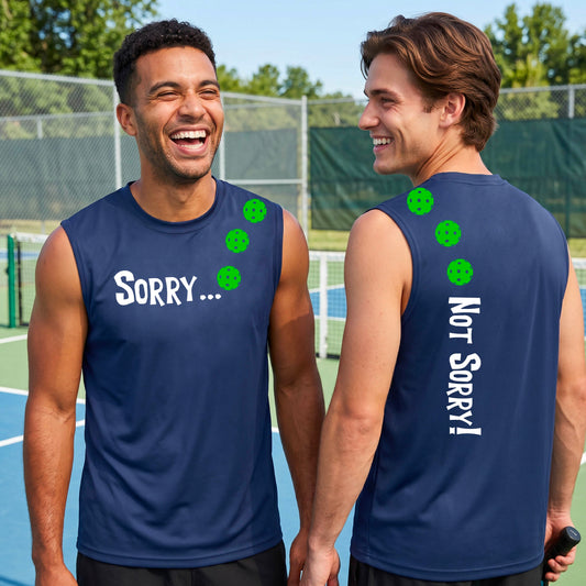 Two men on a pickleball court wearing royal blue sleeveless t-shirt with a front/back graphic design.  The front features the playful word “SORRY…” in bold white lettering, accented with three colorful pickleballs arranged diagonally across the upper chest.  The back design features “NOT SORRY!” in bold white lettering running vertically down the upper back, with three matching colorful pickleballs positioned above lettering.  