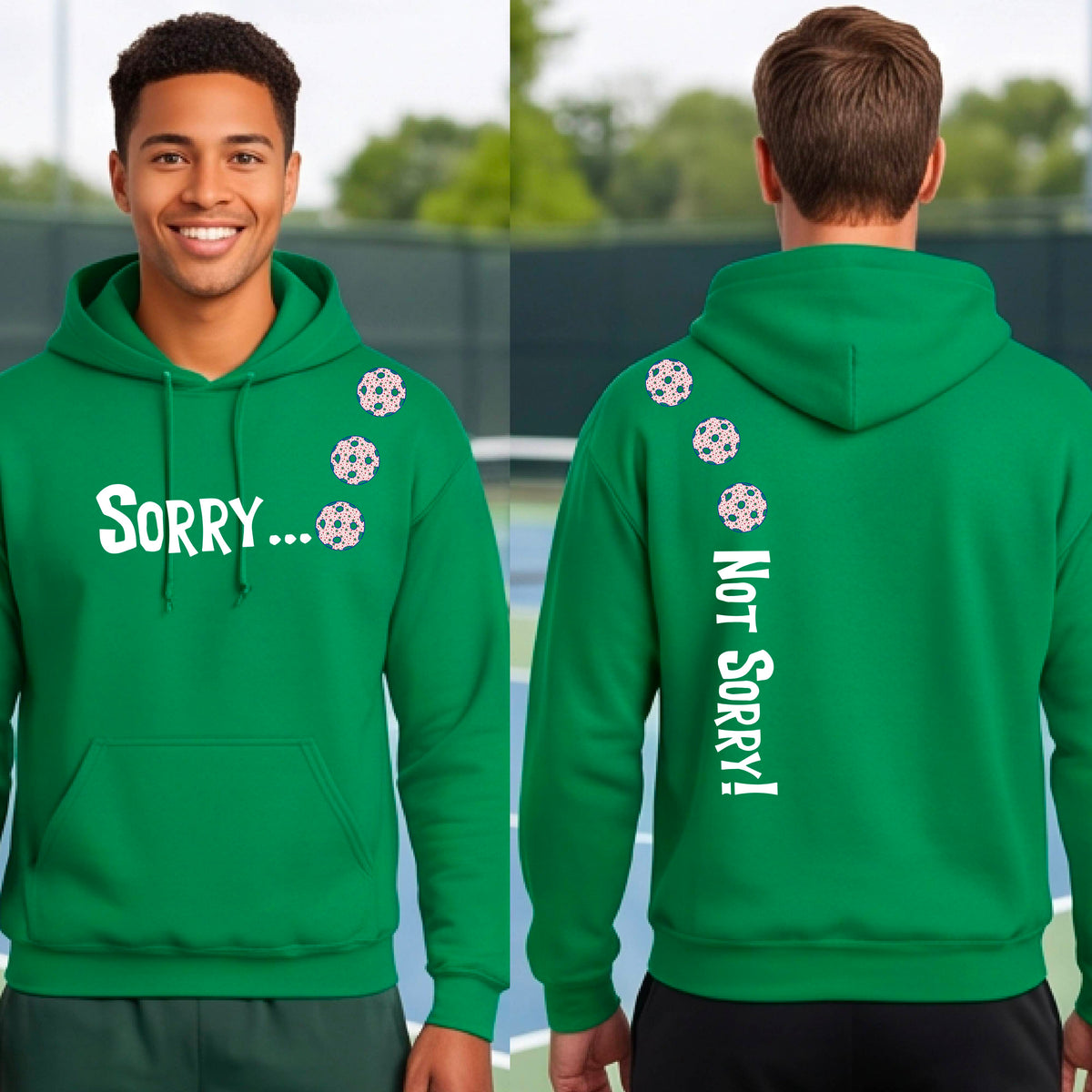 Two men on a pickleball court wearing unisex green pullover hoodies with a front/back graphic design.  The front features the playful word “SORRY…” in bold white lettering, accented with three colorful pickleballs arranged diagonally across the upper chest.  The back design features “NOT SORRY!” in bold white lettering running vertically down the upper back, with three matching colorful pickleballs positioned above lettering.  