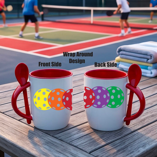 A white and red 12 ounce coffee mug with a built in spoon in the handle with and a fun pickleball graphic of a string of pastel colored pickleballs. 
