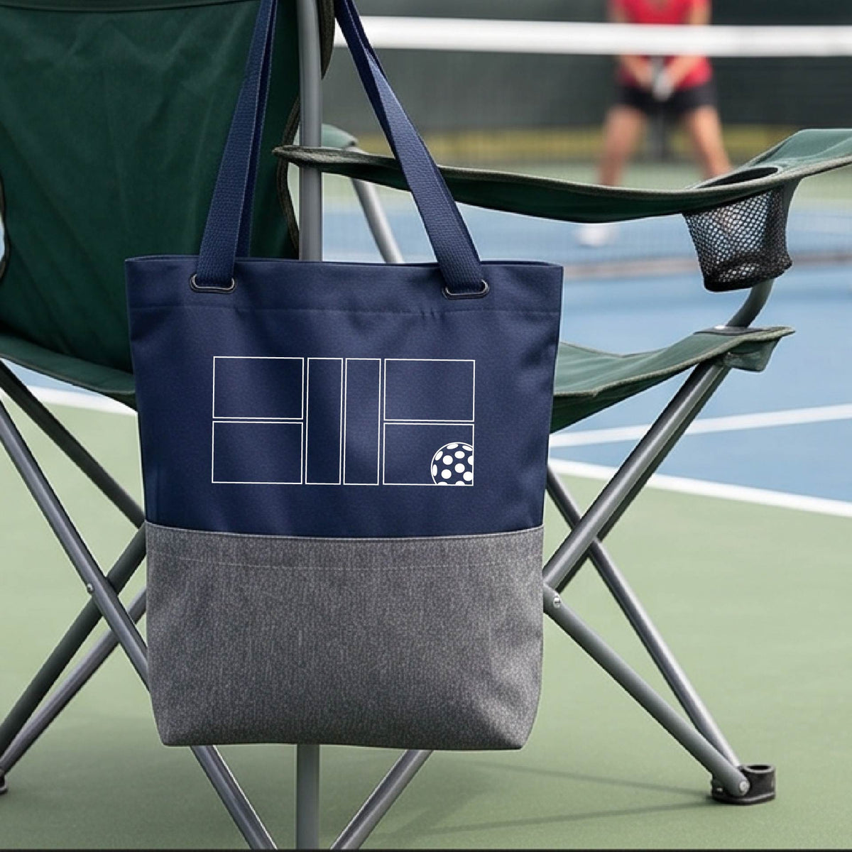 A close-up of a blue and gray medium size tote bag with a white pickleball geometric graphic of court and pickleball.