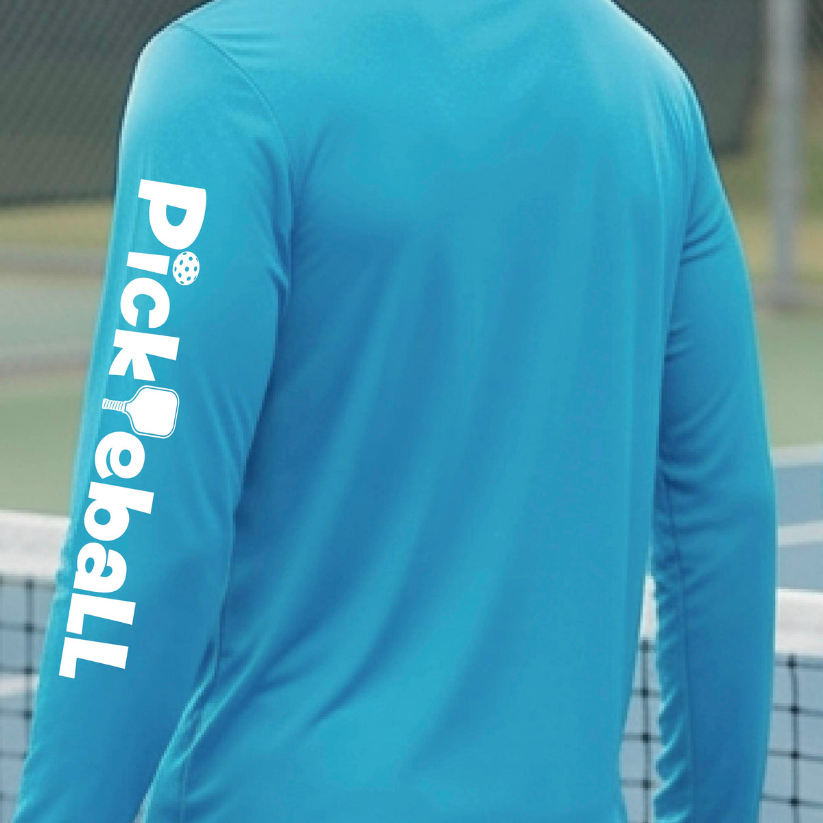 A person wearing a bright turquoise long-sleeve athletic shirt, shown from the back and side. The left sleeve features the word 'Pickleball' printed vertically in white with a pickleball icon integrated into the lettering.