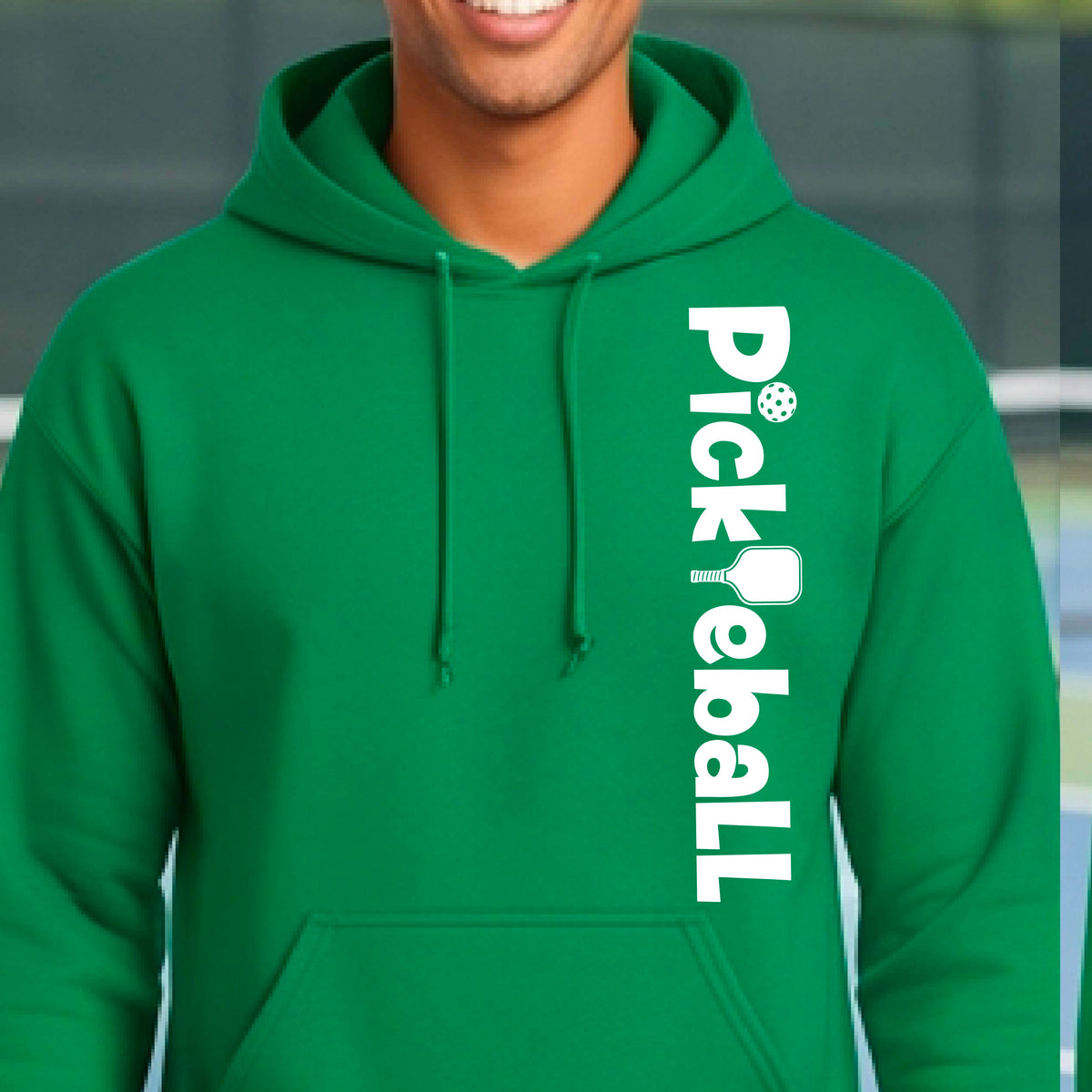 A man wearing a bright green pullover hoodie with 'Pickleball' printed vertically in white on the right side of the chest, with a pickleball and paddle graphic integrated into the text.
