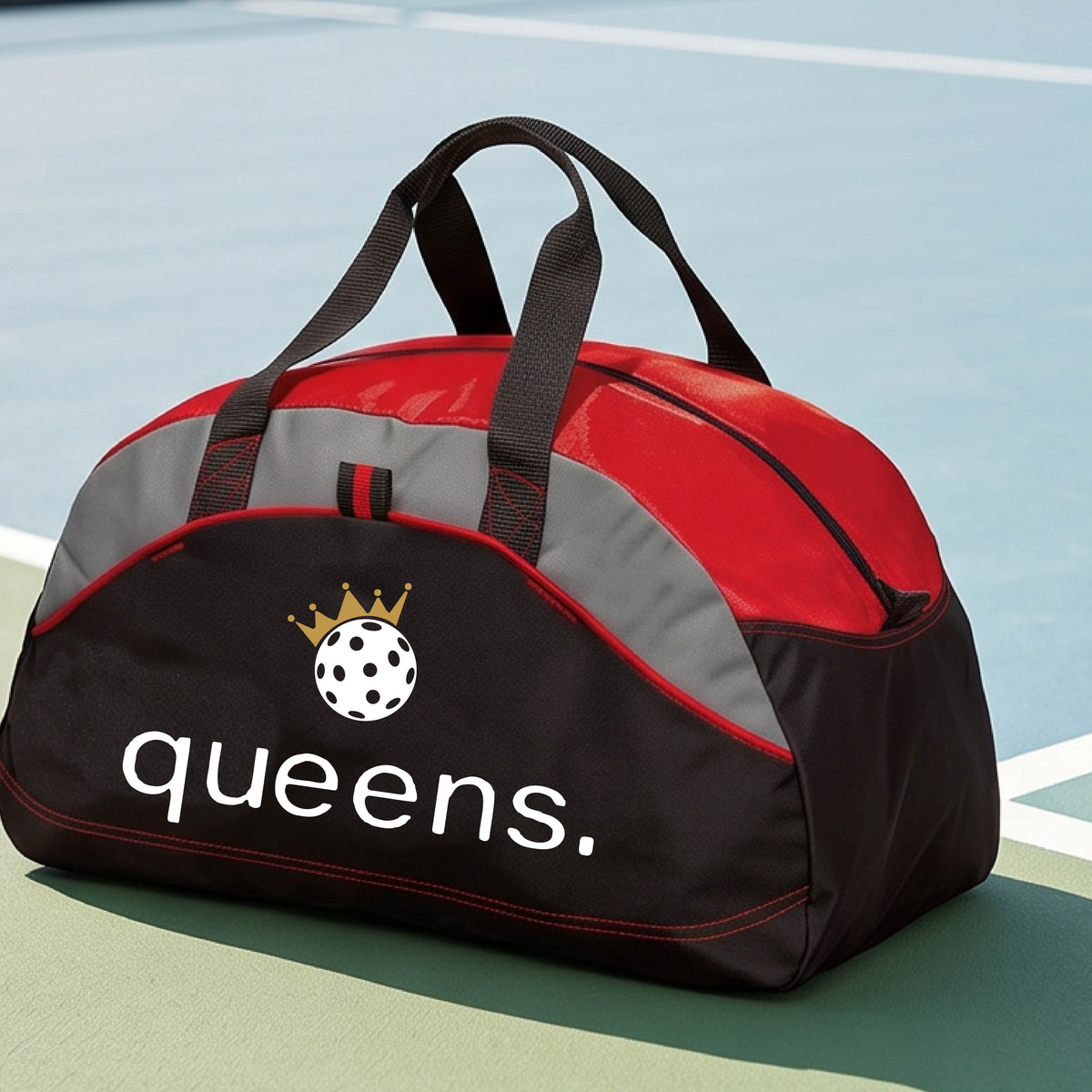 A custom black and red duffel bag with gray panels, featuring the word 'queens.' and a gold crown, and a white pickleball logo on the front.