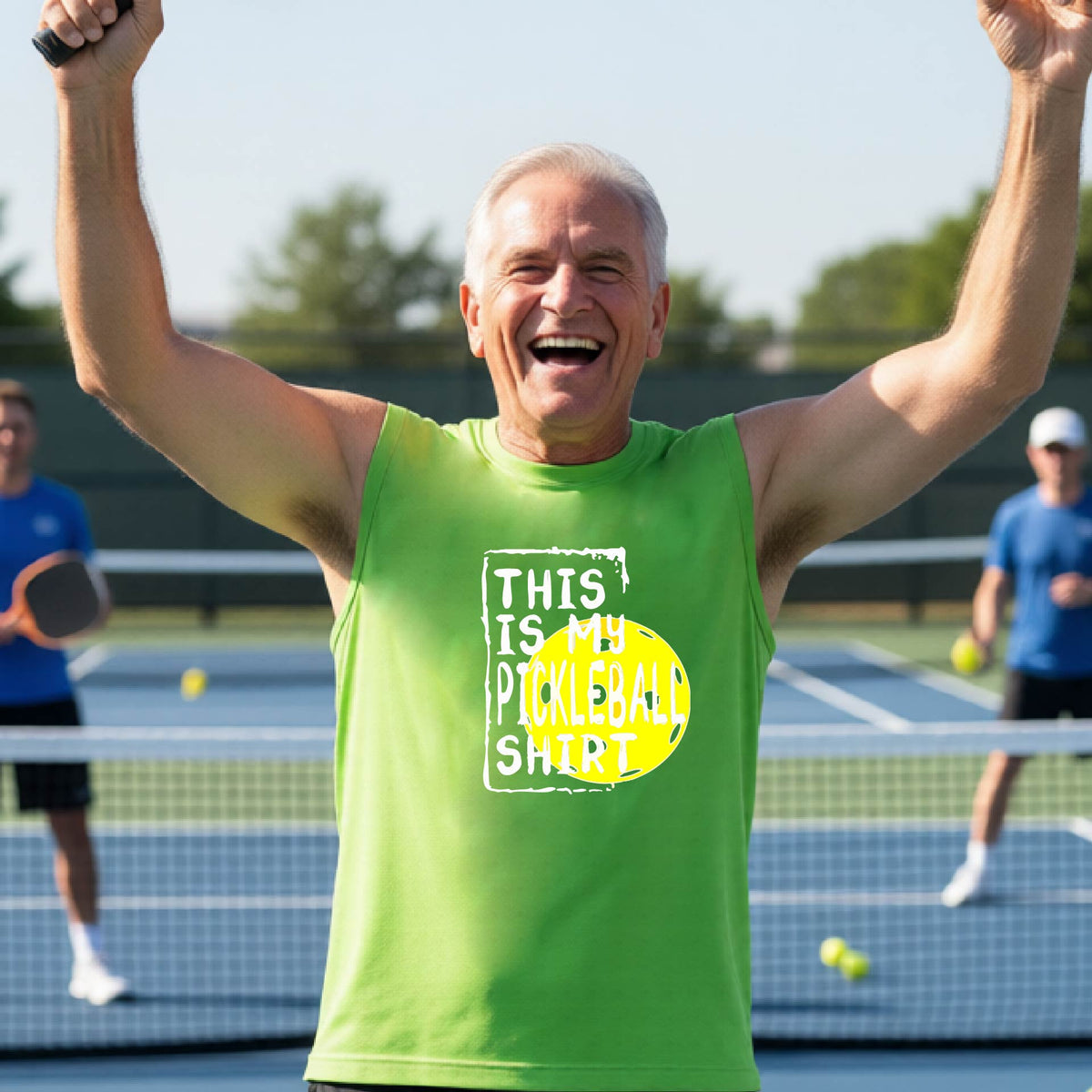 A man on a pickleball court wearing a lime green sleeveless shirt with a yellow and white graphic that reads 'THIS IS MY PICKLEBALL SHIRT' and a yellow pickleball icon.