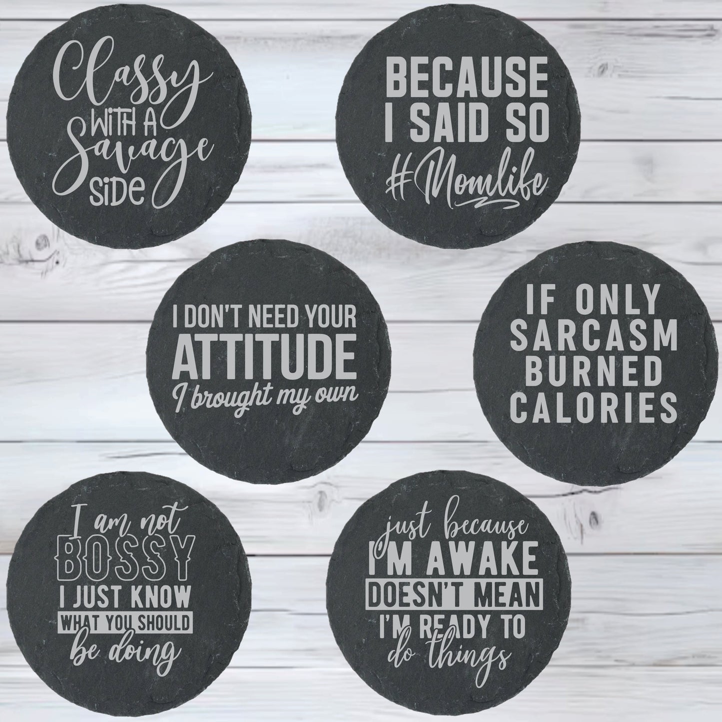 Set of six round black coasters with white text on a wooden surface