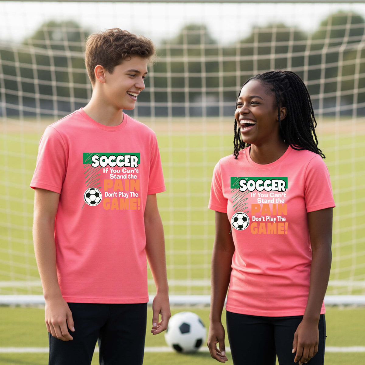 A boy and a girl standing on a soccer field in front of a goal, wearing matching coral pink t-shirts with a green and orange graphic that reads 'SOCCER If You Can't Stand Up Don't Play The GAME!' with a soccer ball graphic.