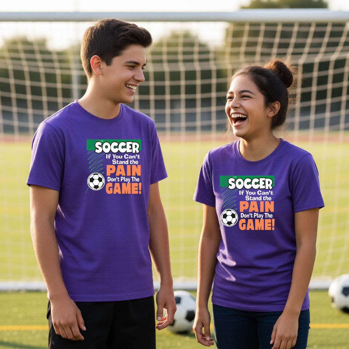 Two young students standing on a soccer field in front of a goal, wearing matching bright purple graphic t-shirts with the text 'SOCCER If You Can't Stand The PAIN Don't Play The GAME!' and a soccer ball graphic.