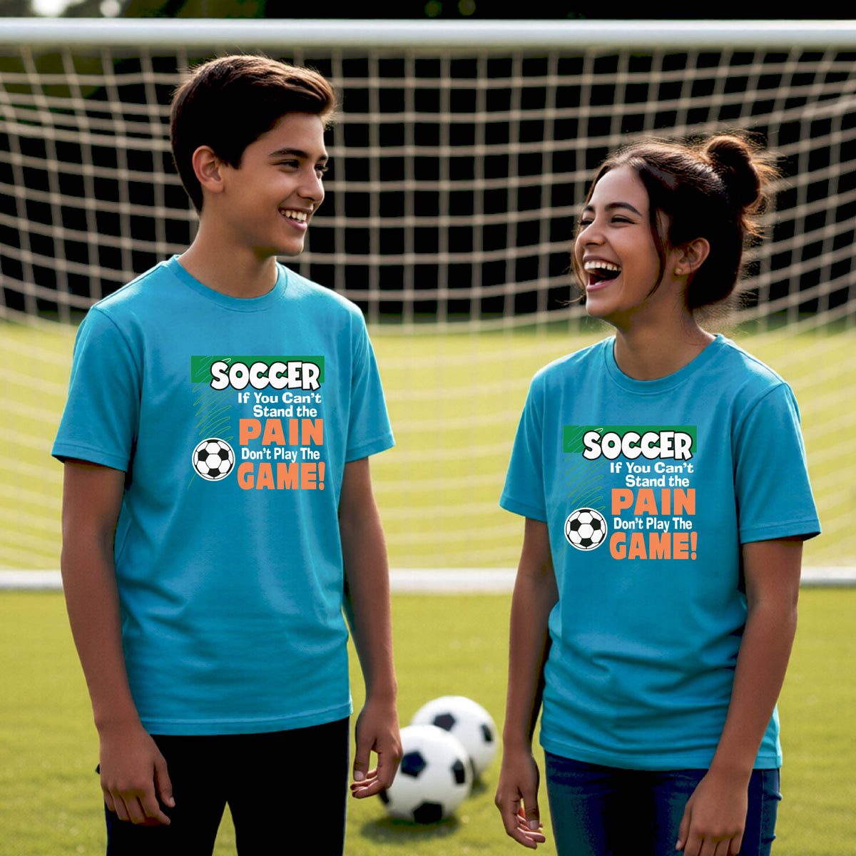 A boy and a girl standing on a soccer field in front of a goal, both wearing matching bright blue t-shirts with a graphic that reads 'SOCCER If You Can't Stand the PAIN Don't Play The GAME!' in green, white, and orange.