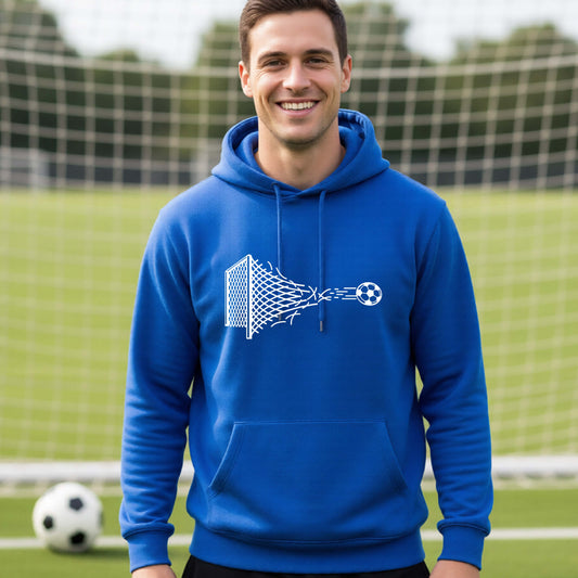 A smiling man wearing a royal blue hoodie pullover standing on a soccer field in front of a goal net. with a white graphic of a soccer ball shooting through and tearing up a soccer goal net, printed on the chest.