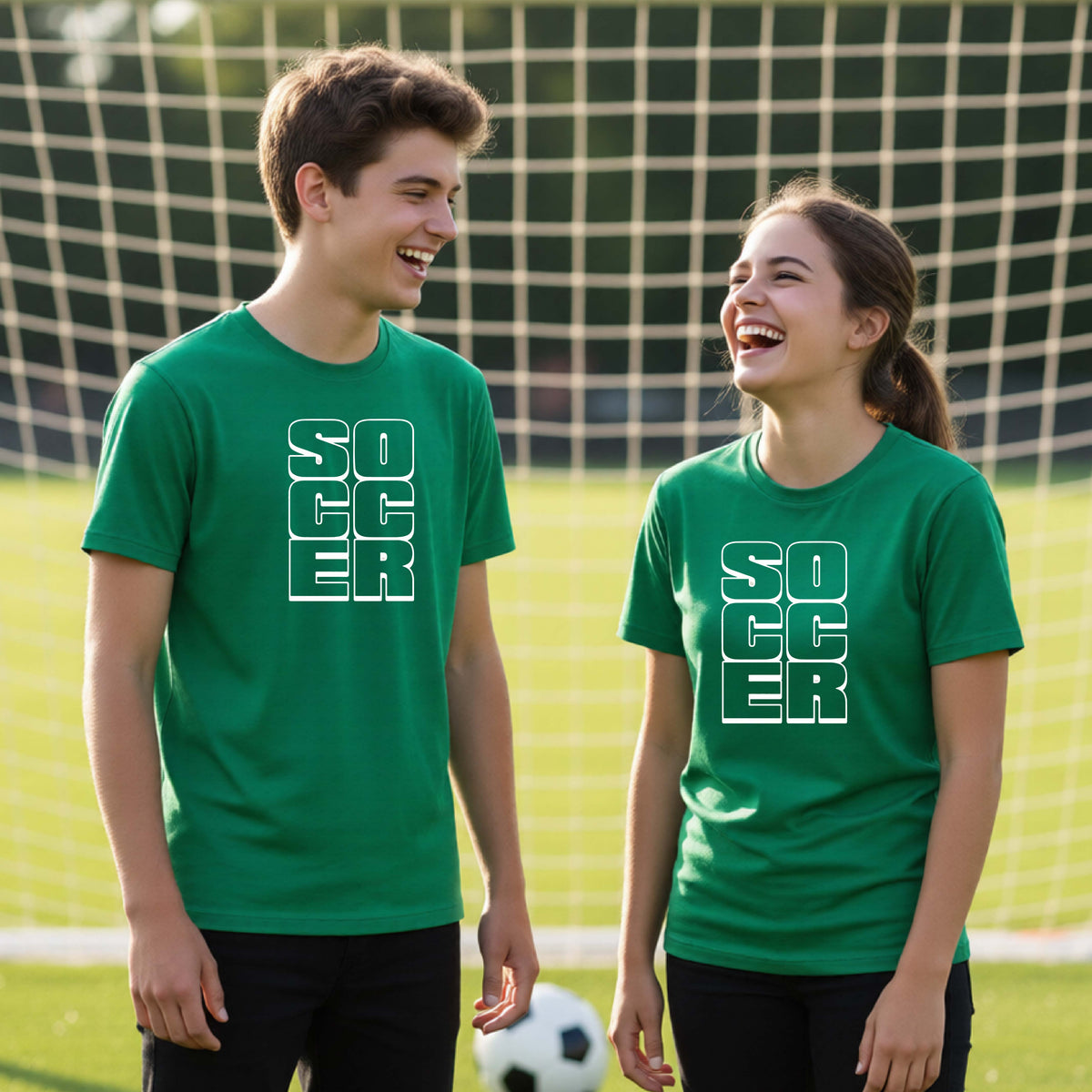 Two young athletes wearing matching green t-shirts, standing in front of a soccr goal and balls, with a white graphic of the word ‘SOCCER’ stacked in a 2x3 arrangement, printed on the chest.
