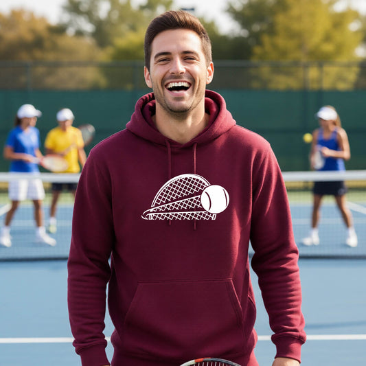 A man on a blue tennis court holds a tennis racket and wears a maroon unisex hoodie pullover with a white graphic of a half a tennis racquet with a ball streaking over it. 