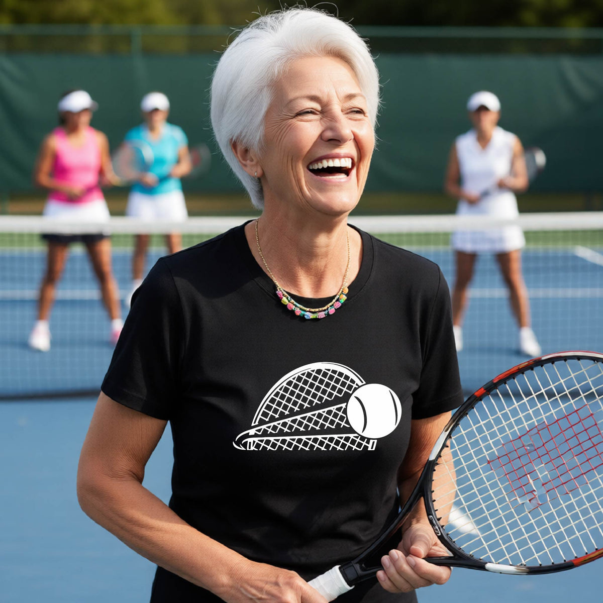 A woman on a blue tennis court holds a tennis racket and wears a black short-sleeve T-shirt with a white graphic of a half a tennis racquet with a ball streaking over it. 