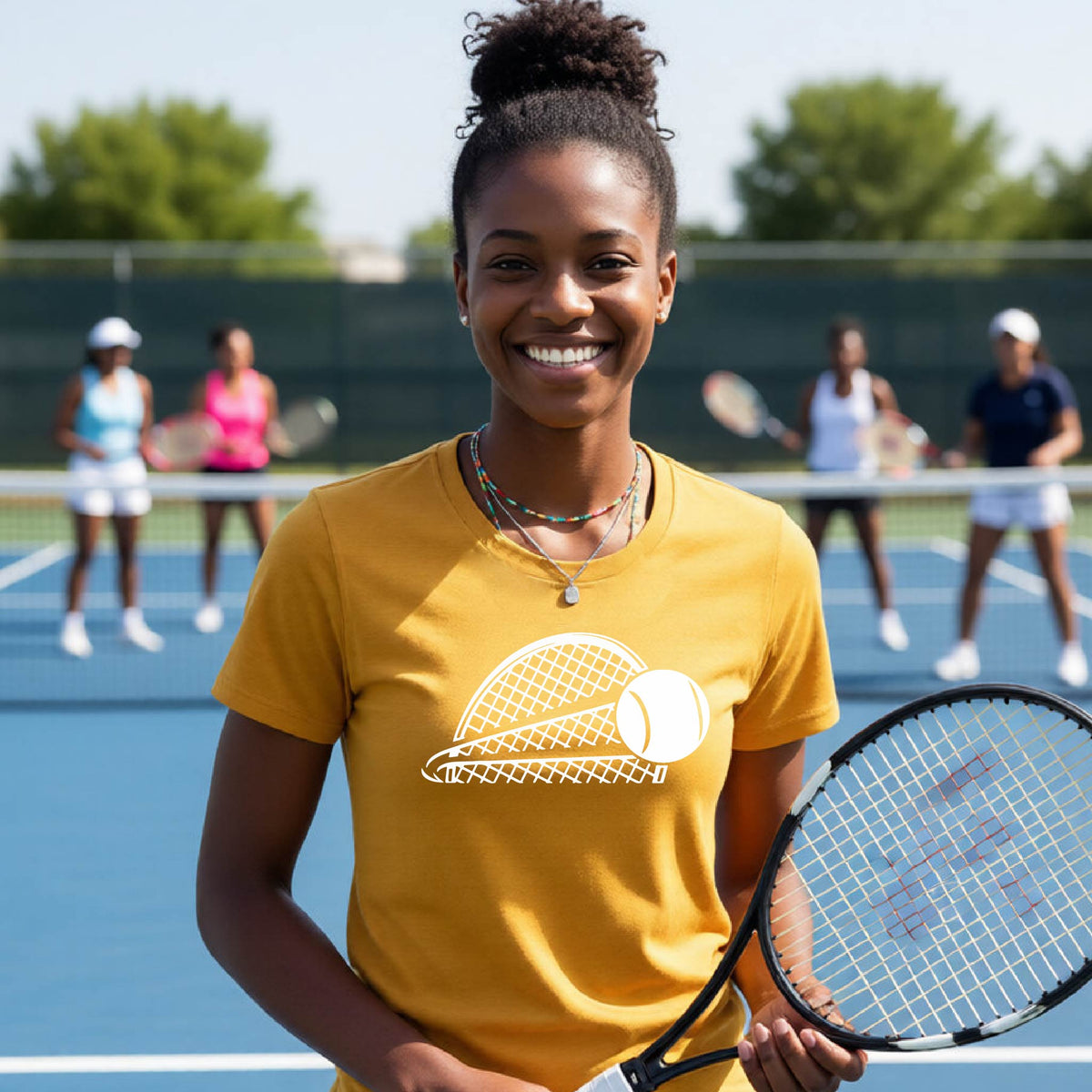 A woman on a blue tennis court holds a tennis racket and wears a gold short-sleeve T-shirt with a white graphic of a half a tennis racquet with a ball streaking over it. 