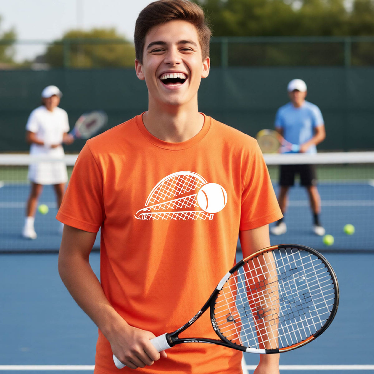 A young person  on a blue tennis court holds a tennis racket and wears an orange short-sleeve T-shirt with a white graphic of a half a tennis racquet with a ball streaking over it.  