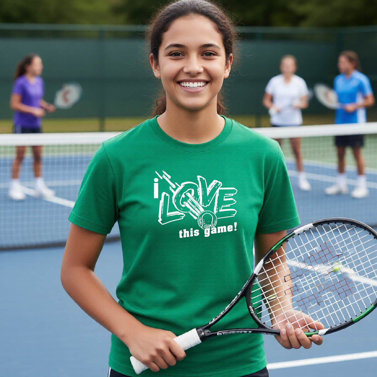 A smiling young woman on a tennis court wearing a green graphic T-shirt that reads 'i LOVE this game!' in white and teal, holding a tennis racket. Other players are blurred in the background on a blue tennis court.