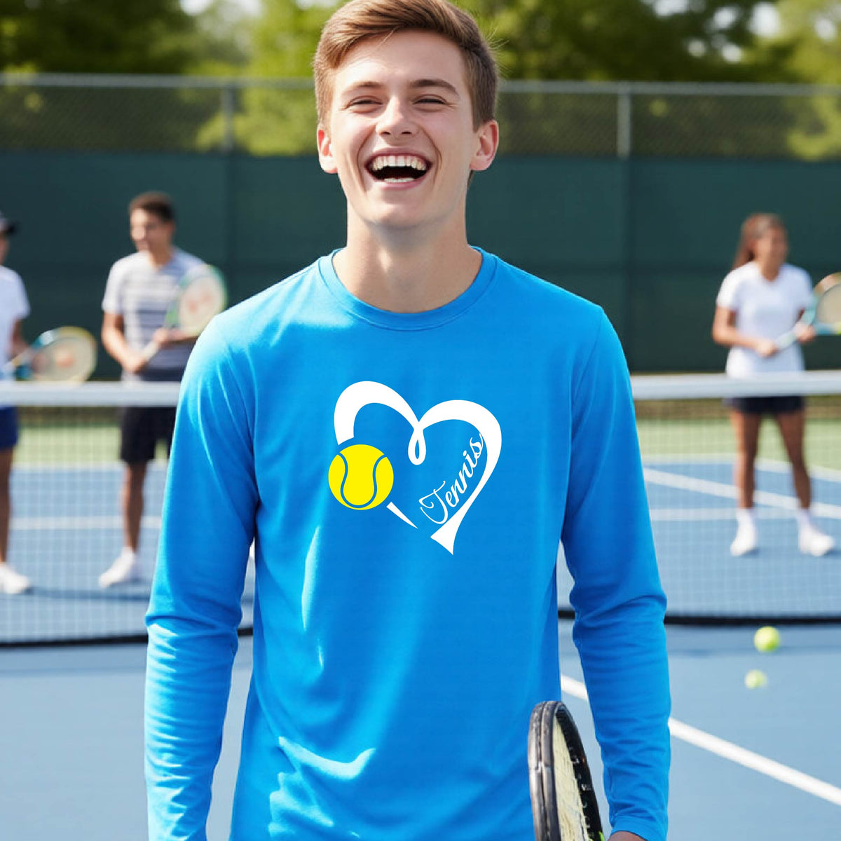 A man laughing on a tennis court wearing a bright blue long-sleeve athletic shirt with a white heart outline, a yellow tennis ball graphic, and the word 'Tennis' printed on the front.