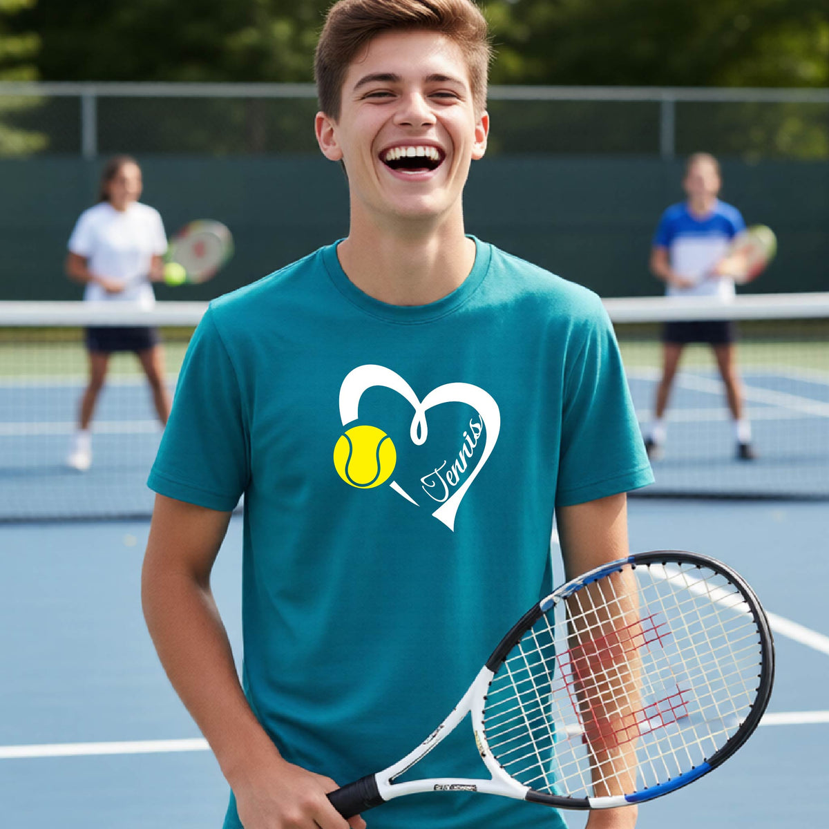 A young man smiling on a tennis court wearing a teal t-shirt with a white heart graphic, a yellow tennis ball, and the name 'Tennis' in script. He is holding a tennis racket, with other players blurred in the background.