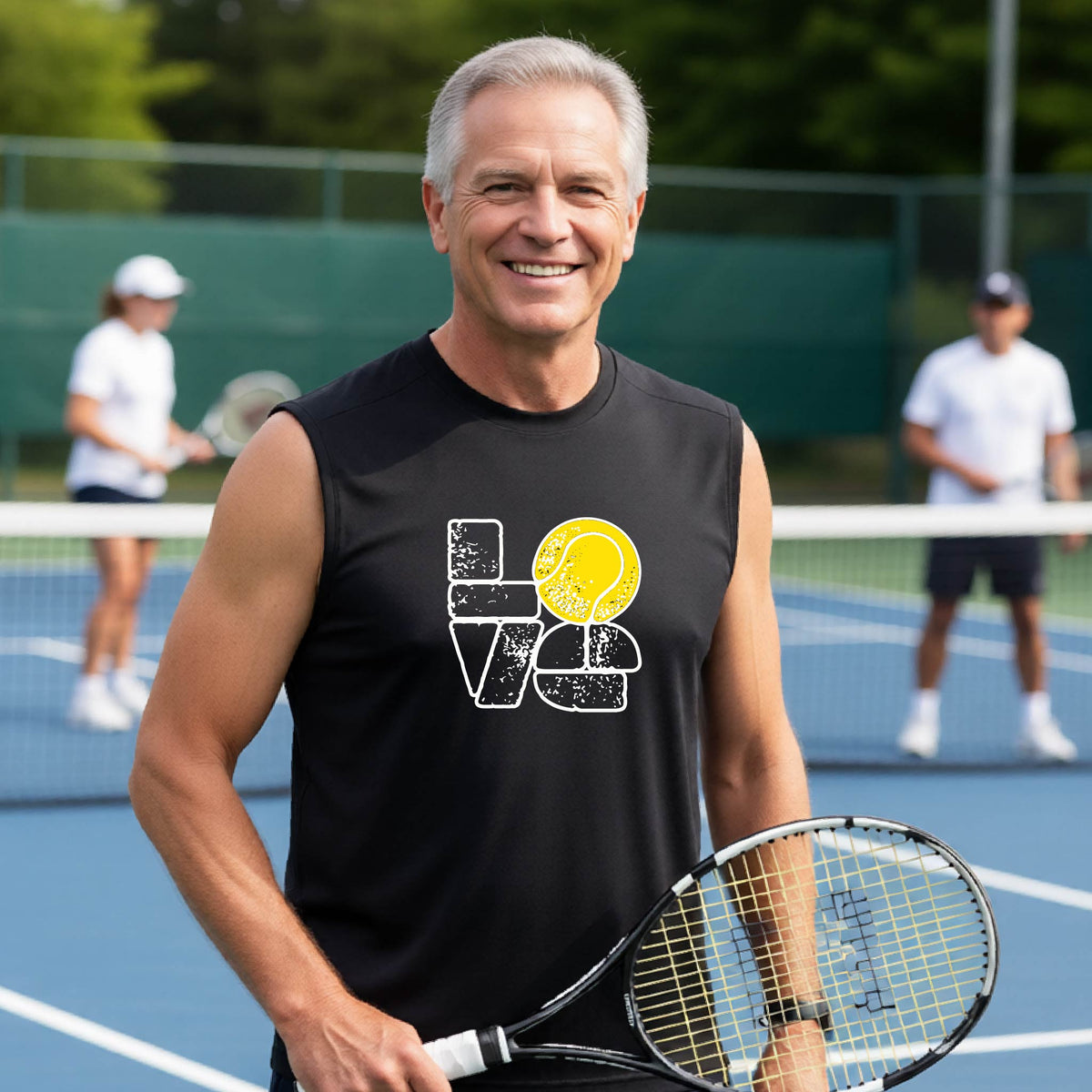 A man wearing a black sleeveless t-shirt with a white and yellow tennis-themed graphic "LOVE" with a tennis ball replacing the O, with a tennis  court and players in the background.