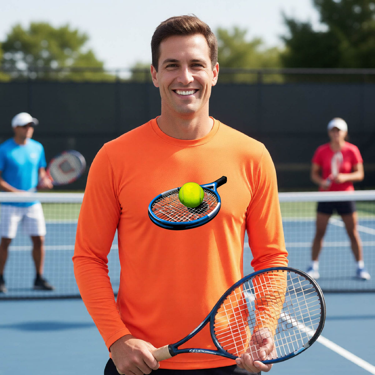 A man on a tennis court wearing a bright orange long-sleeve shirt with a graphic of a tennis racket and yellow tennis ball on the chest, holding a tennis racket.