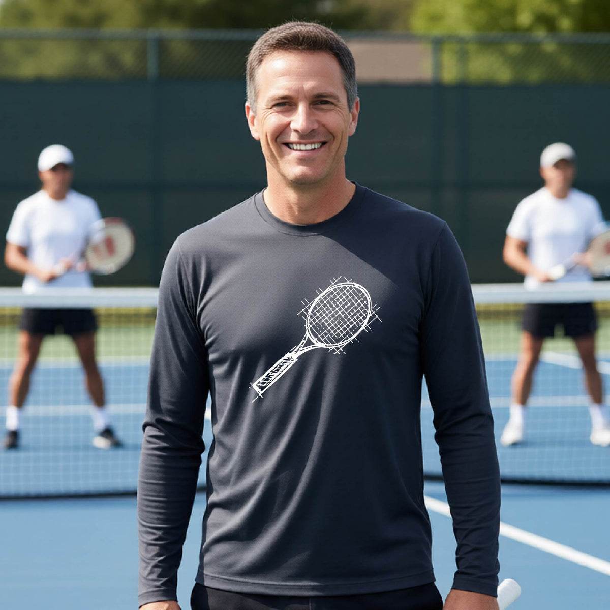A man on a blue tennis court holds a tennis racket and wears a dark gray long-sleeve T-shirt with a white retro tennis racquet graphic.  