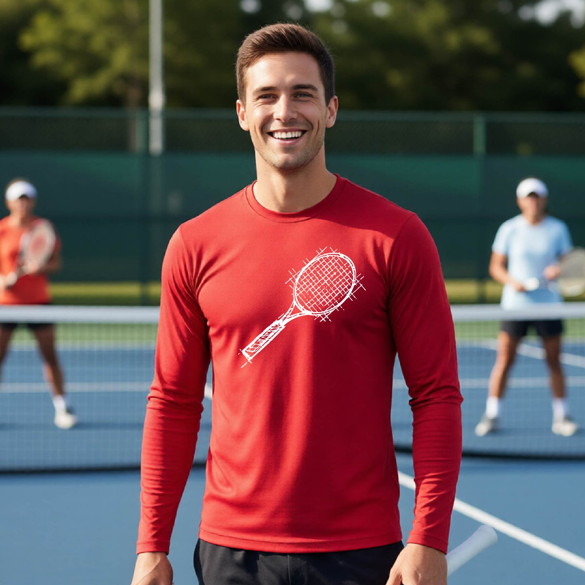 A man on a blue tennis court holds a tennis racket and wears a red long-sleeve T-shirt with a white retro tennis racquet graphic.  