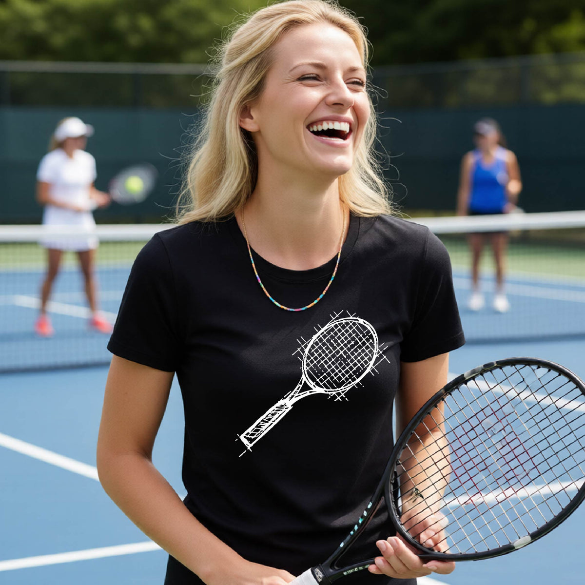 A woman on a blue tennis court holds a tennis racket and wears a black short-sleeve T-shirt with a white retro tennis racquet graphic.  