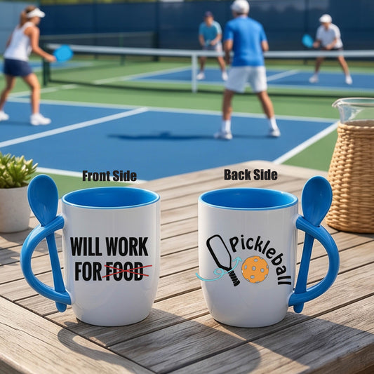 a white and blue 12 ounce coffee mug with a built in spoon in the handle with the wraparound text 'WILL WORK FOR FOOD" and a pickleball paddle and ball graphic.