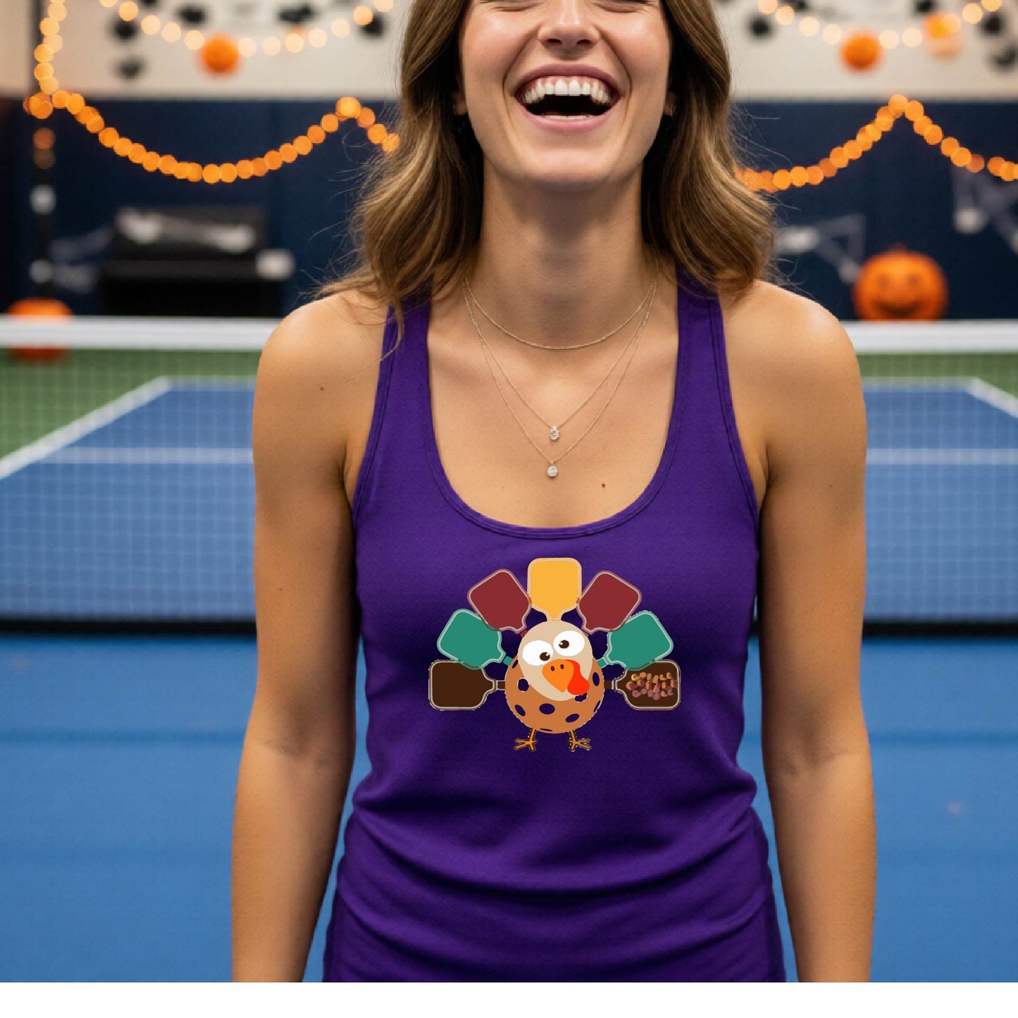 A purple racerback tank top featuring a graphic of a cartoon turkey. The turkey's tail feathers are depicted as colorful pickleball paddles in shades of yellow, maroon, teal, and brown,.