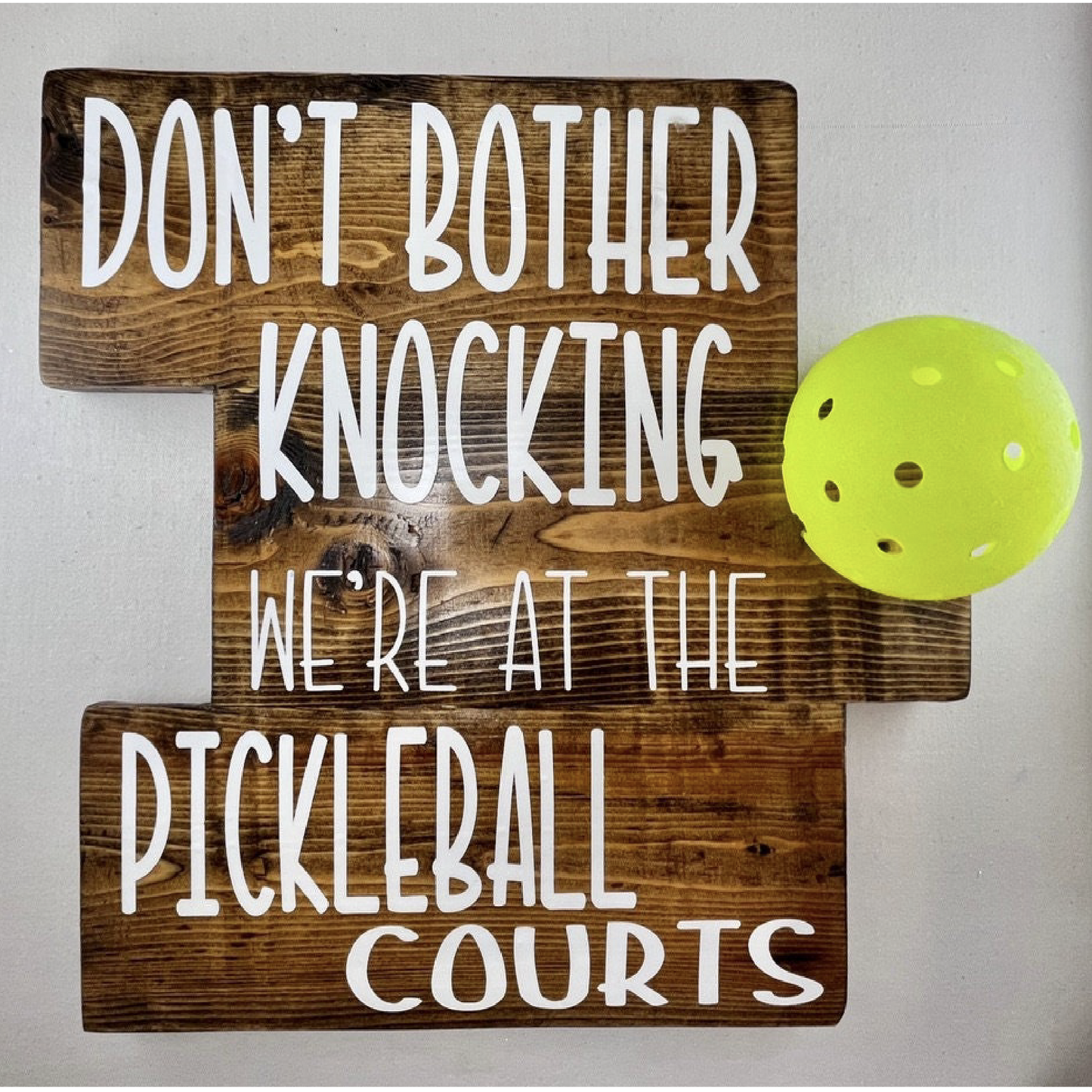 We're at the Pickleball Courts - Home Decor Door Decorations  Decorate your porch with this funny and super fun Pickleball sign. This sign uses an upcycled pickleball! It also comes in a "vintage" style. You get to customize the color of sign and the color of words you want to help match any home design.